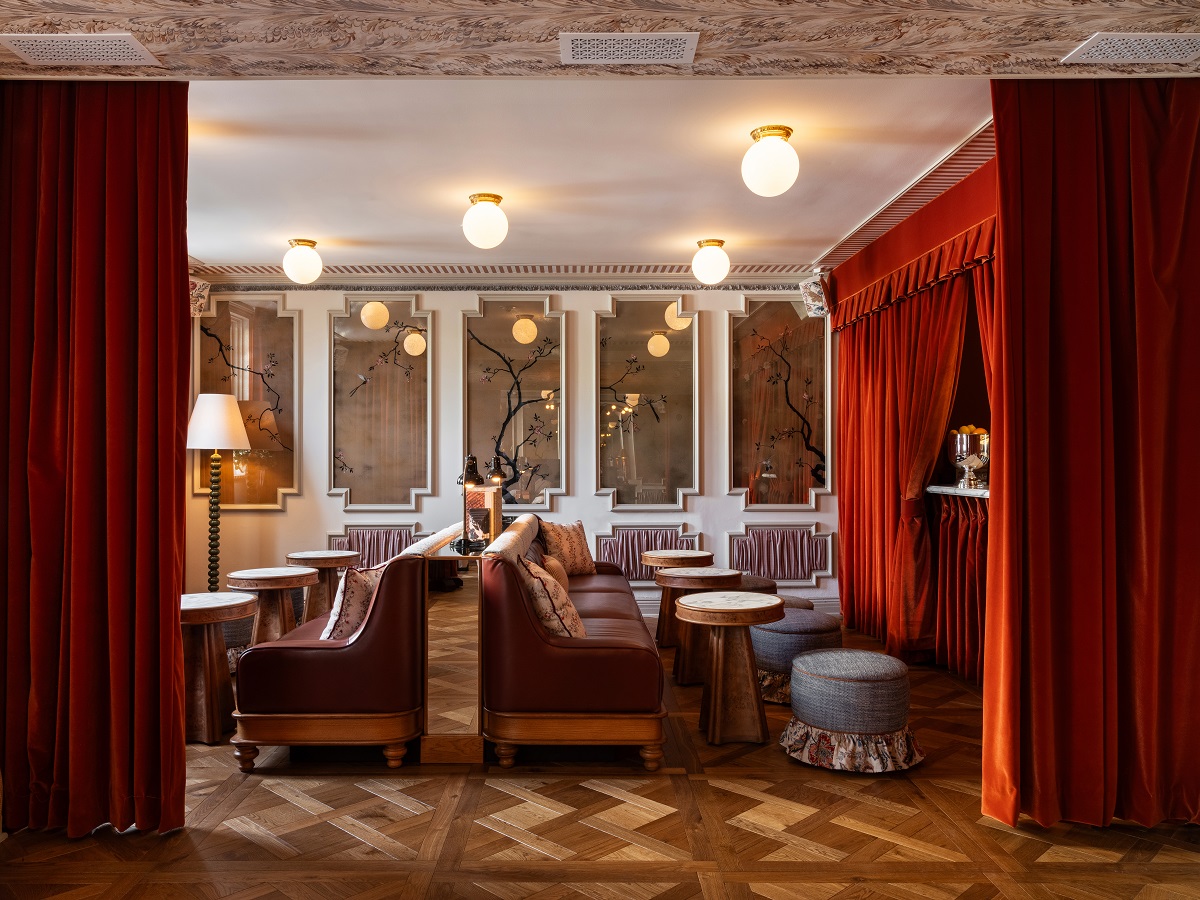 Cortinas rojas teatrales y sillas de cuero en el Hotel Beverly Hills.