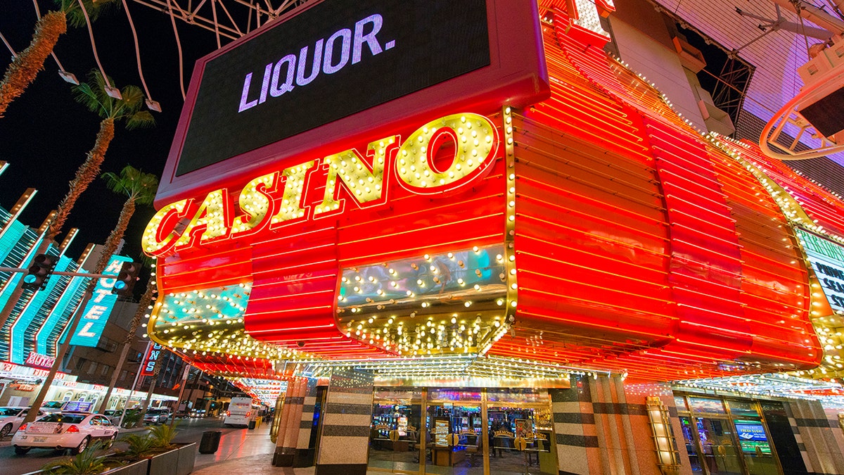 Un gran casino de neón y un cartel de licores iluminados por la noche en Fremont Street en Las Vegas